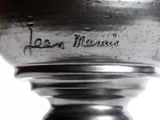 a close up of a silver vase with writing on it
