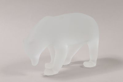 a frosted glass sculpture of a polar bear on a white surface