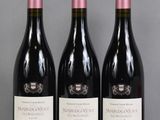 three bottles of wine are lined up on a table