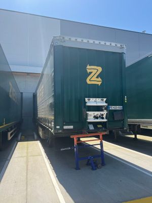 two semi trucks parked next to each other in a warehouse