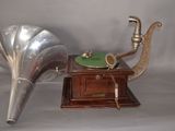 a silver gramphone and a green record player next to each other