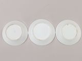 three white plates with white rims sit on a white surface