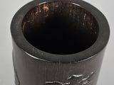 a small black vase with a design on it