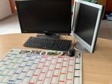 a desk with two monitors and a keyboard on it