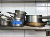 de nombreuses casseroles et poêles sur l'étagère de la cuisine