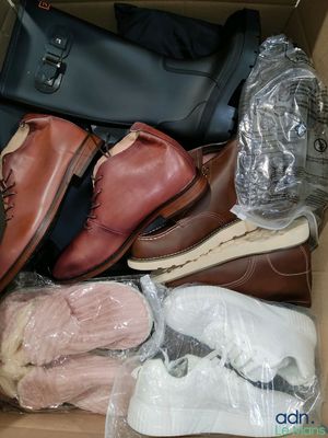 plusieurs paires de chaussures dans une boîte posée sur le sol