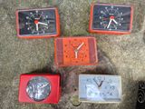 several different colored clocks sitting on the ground next to a pair of shoes