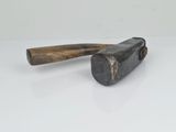a close up of a hammer with a wooden handle on a white surface
