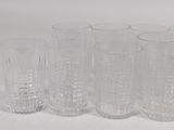 six glasses sitting next to each other on a white surface