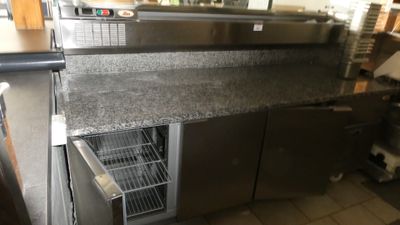 une photo d'une cuisine professionnelle équipée d'appareils électroménagers en acier inoxydable et de plans de travail en granit