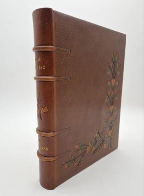 an old brown leather book with a floral design on the cover