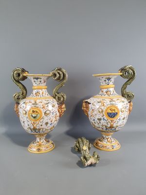 two vases with handles and handles are sitting on a gray surface