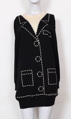 un pull noir avec des coutures et des boutons blancs sur le devant