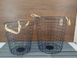 pair of wire baskets with wooden handles on a wooden floor