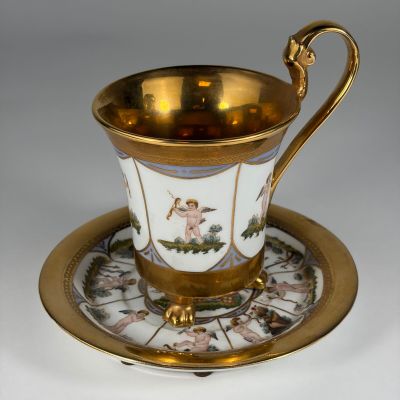 an antique cup and saucer with a gold rim on a saucer