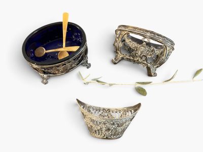 three bowls and spoons sitting on a white surface