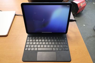 un ordinateur portable posé sur un bureau, avec un clavier