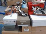 boxes of shoes are stacked on top of a cart in a warehouse