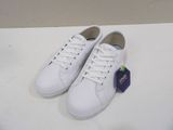 white leather sneakers with white laces are on a white surface