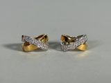 a pair of gold and diamond earrings on a white surface