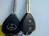 two car keys sitting next to each other on top of a yellow piece of paper