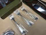 a box of silverware sitting on a table next to a knife and fork