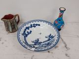 a blue and white bowl and a vase on a table