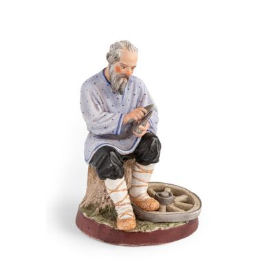 figurine représentant un vieil homme assis sur une souche d'arbre, tenant un panier de pain