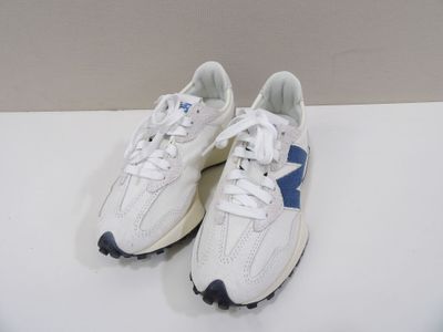 baskets blanches et bleues avec des semelles noires sur un fond blanc