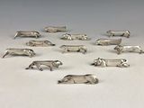 silver plated figurines of animals arranged in a circle on a white surface
