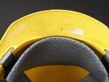 a close up of a yellow safety helmet on a black background