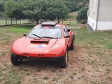 a red car that is parked in the grass