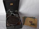 an old record player sitting in a suitcase next to a stack of books