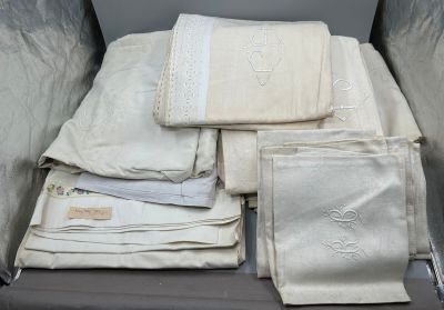 beaucoup de linge de maison dans une valise posée par terre