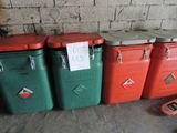 trois poubelles rouges et vertes placées les unes à côté des autres dans une pièce