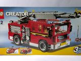 une boîte avec un camion de pompiers lego à l'intérieur