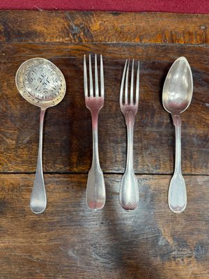 several spoons, forks, and a spoon rest on a wooden table
