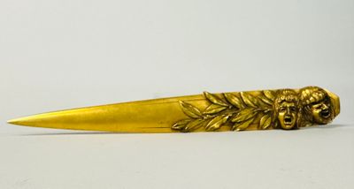 gold plated knife with a lion head and leaves on the blade