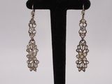 a close up of a pair of earrings on a black stand