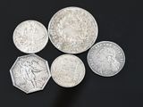six different british coins on a black surface with a black background