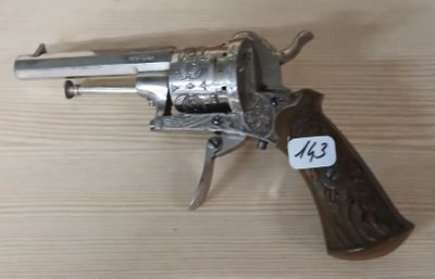 un pistolet muni d'une étiquette, posé sur une table
