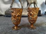 two gold vases sitting next to each other on a table