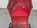 a red toy stroller with a basket on top of it