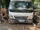 un camion garé à côté d'une pile de bois