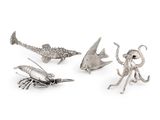 trois figurines d'animaux en métal argenté sur fond blanc