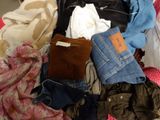 a pile of clothes that is sitting on a bed
