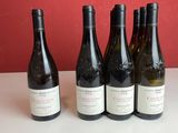 quatre bouteilles de vin sont alignées sur une table