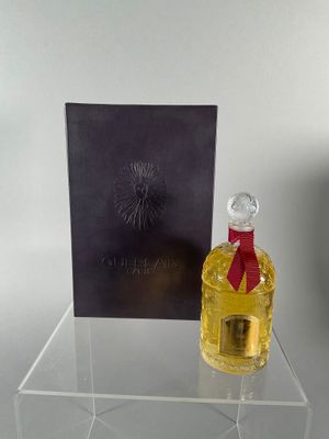 a bottle of perfume sitting on a clear table