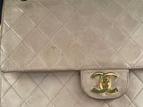 a beige purse with a gold logo on it