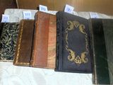 several old books are lined up on a table with tags on them